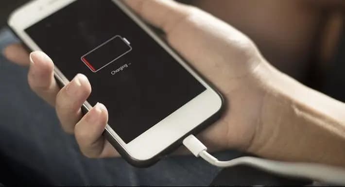 iPhone conectado al cargador mostrando batería descargada