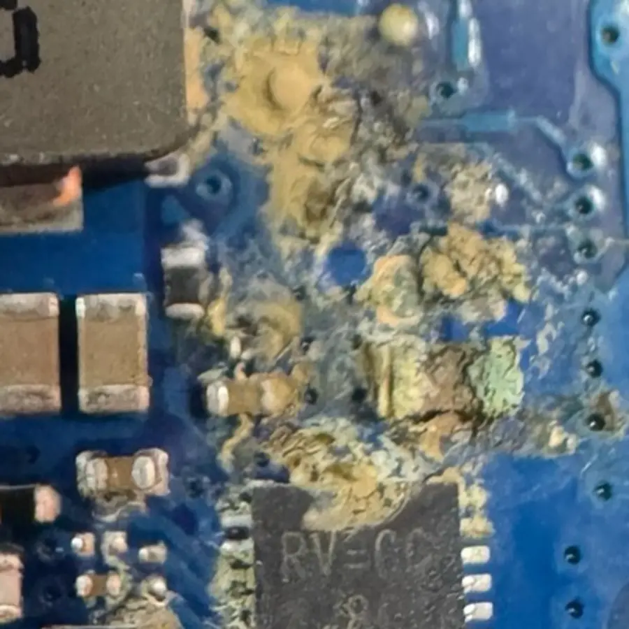 Corrosión amarillenta sobre los componentes de una tarjeta madre de laptop a los pocos días de un derrame, en el laboratorio de Repárame en Monterrey