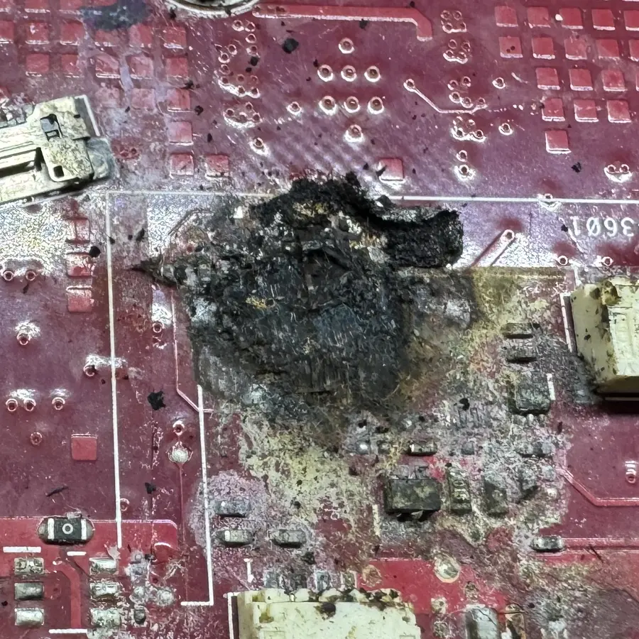 Zona quemada en la tarjeta madre de una laptop que se siguió usando después de un derrame de líquido